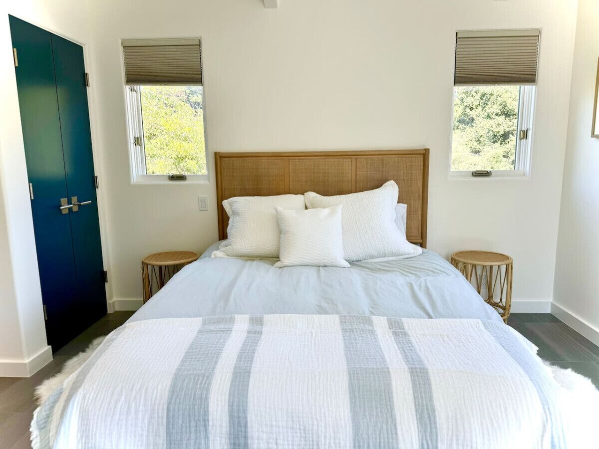 Une chambre à coucher avec un grand lit, deux tables de chevet et une porte.