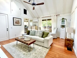 A spacious living room with a white sofa, a wooden coffee table, and a ceiling fan. - Little Nicasio with breathtaking views (Nicasio)