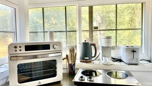 Una cucina con forno a incasso, macchina del caffè e tostapane sul ripiano.