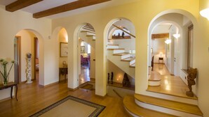 A spacious hallway with wooden flooring, a central staircase, and arched doorways leading to different rooms. - Stunning villa with pool in the Marche countryside, just 10 minutes from the beaches of Senigallia (Senigallia)