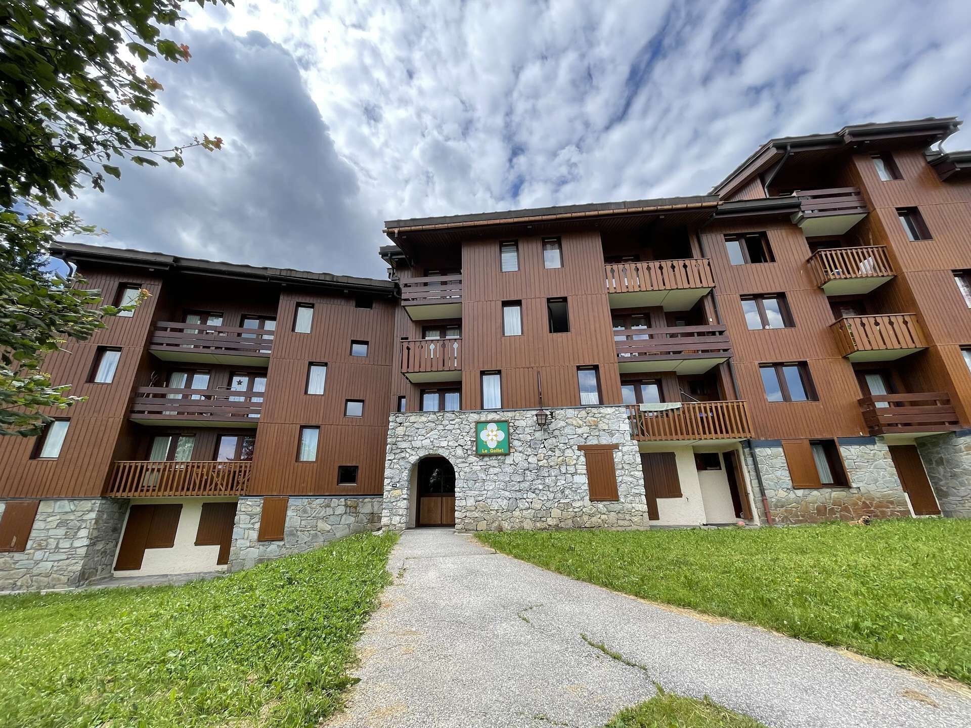 Un hôtel à plusieurs étages, doté d’une façade en pierre, de balcons et d’une entrée centrale.