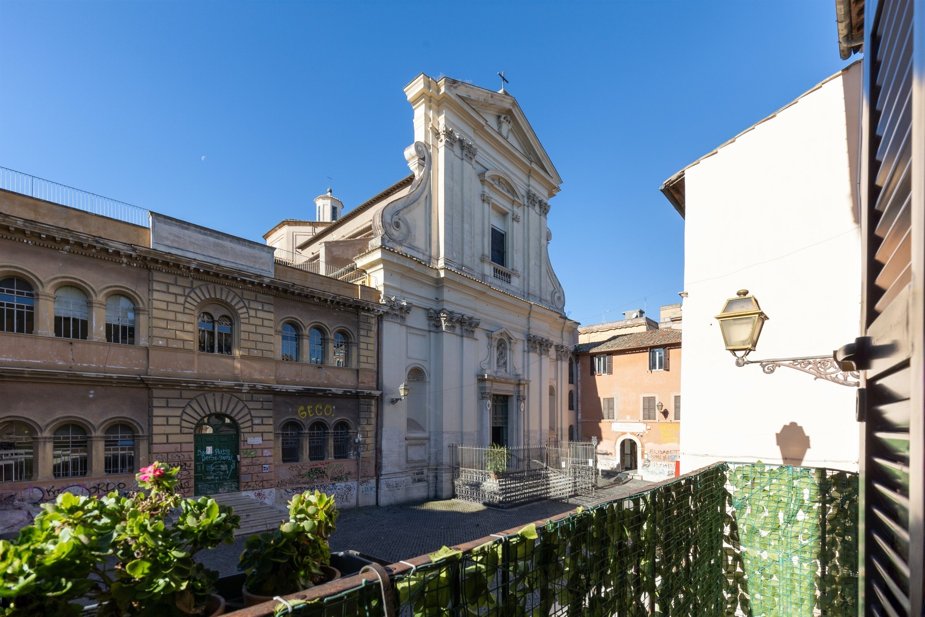 A historic building with a central entrance, arched windows, and a balcony.