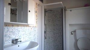 A bathroom with a shower, sink, and toilet. - A stone's throw from the sea (Marina di Campo)