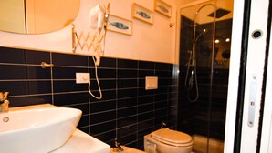 Un baño con lavamanos, inodoro y ducha.