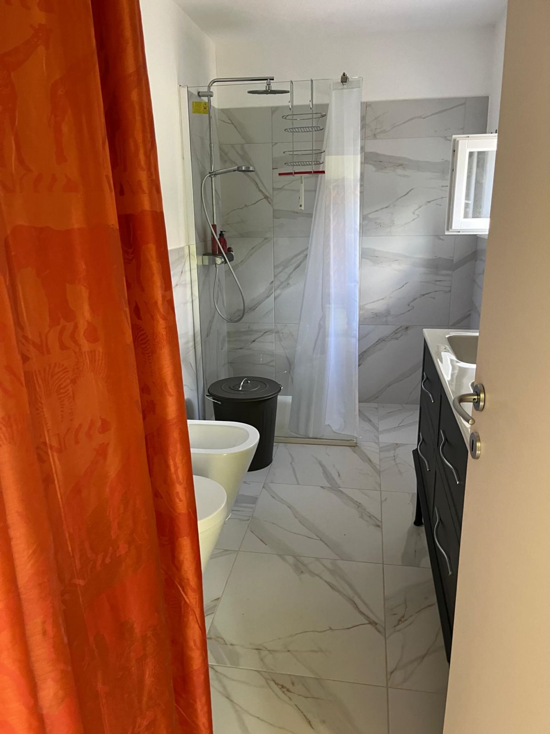Une salle de bain moderne équipée d’une douche, de toilettes et d’un lavabo.