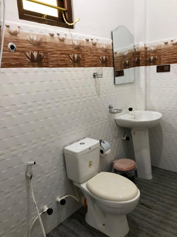 Un baño con inodoro, lavabo y espejo.