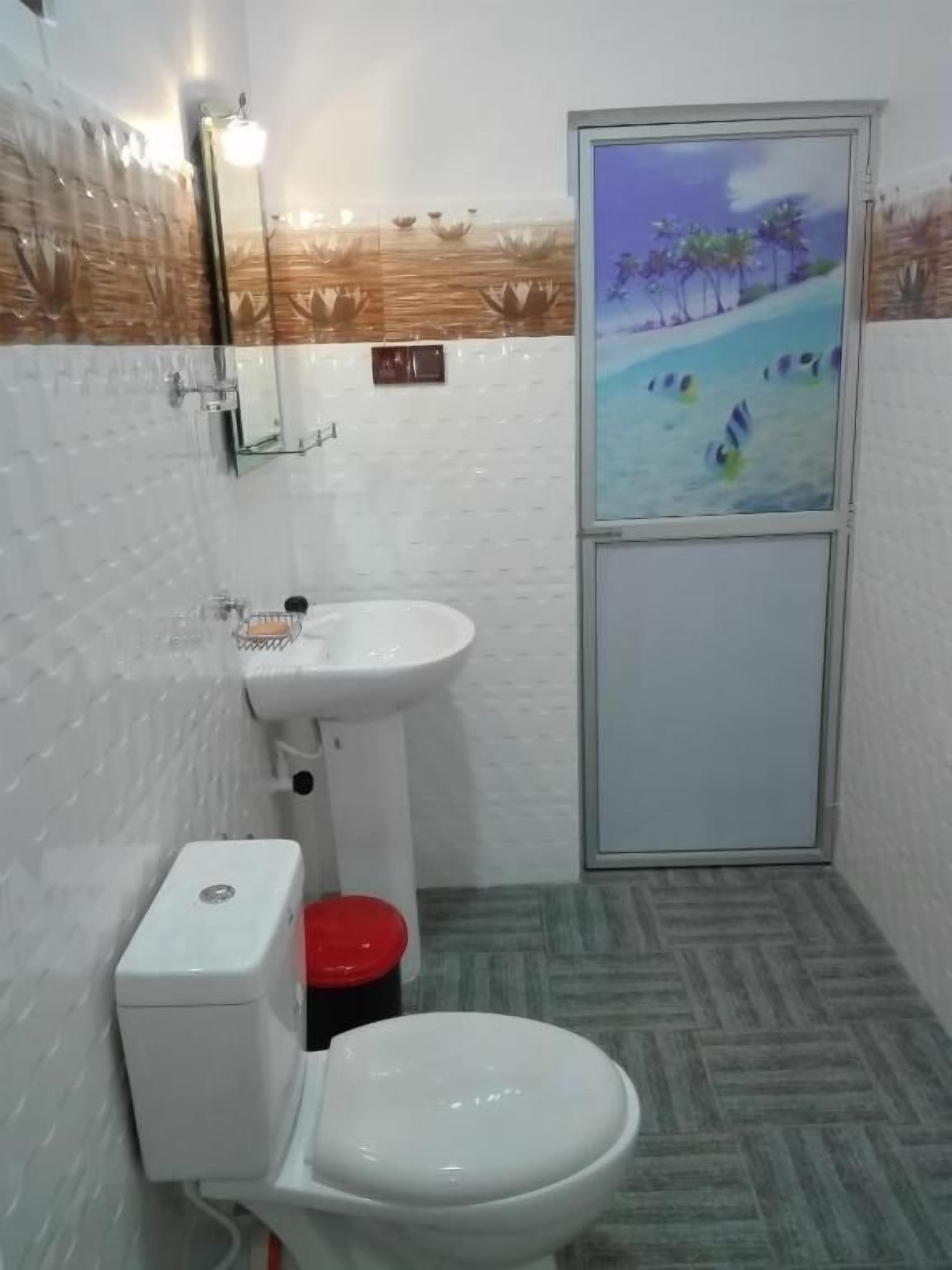 Un baño pequeño con inodoro, lavamanos y zona de ducha.