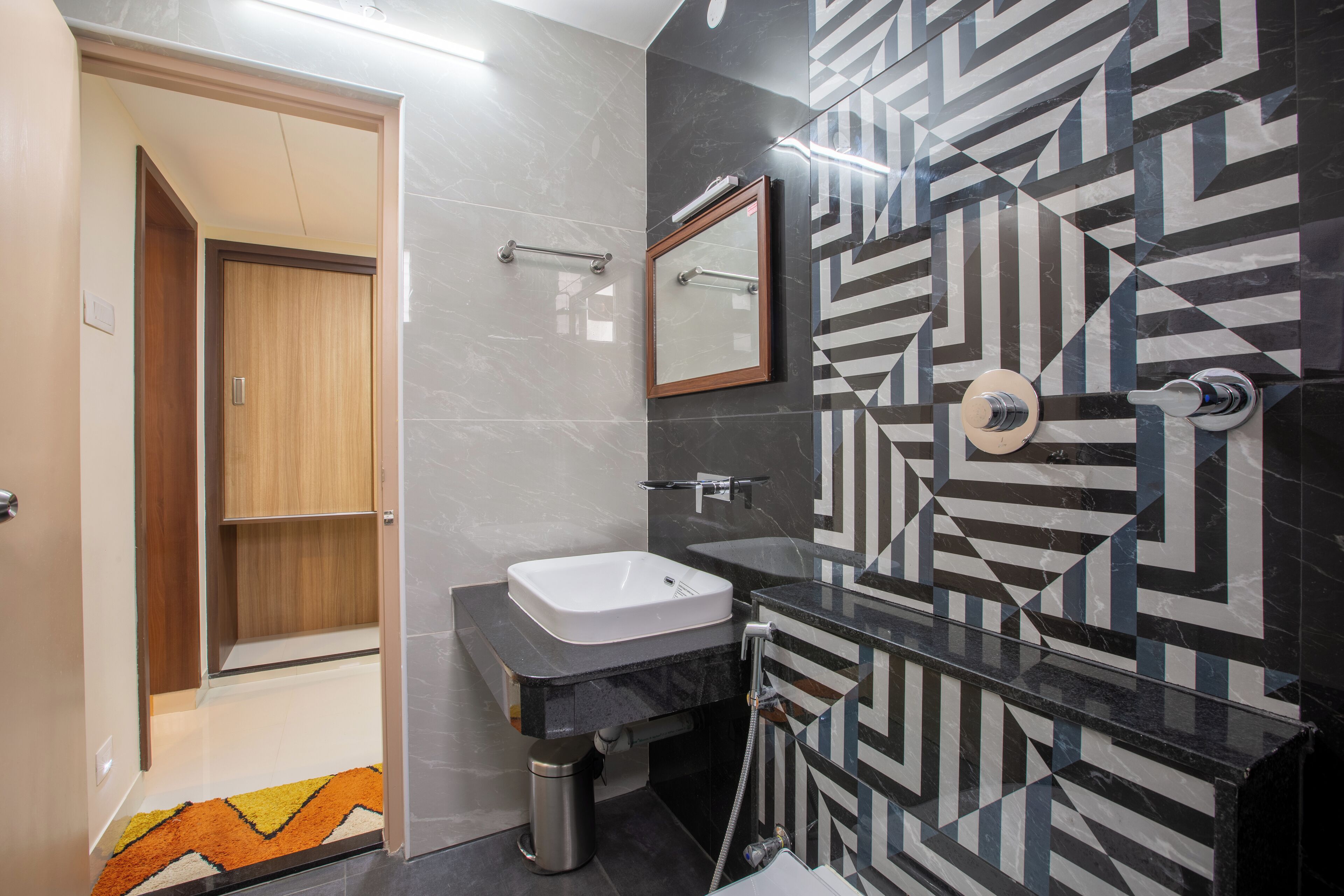 A modern bathroom with a sink, mirror, and shower.