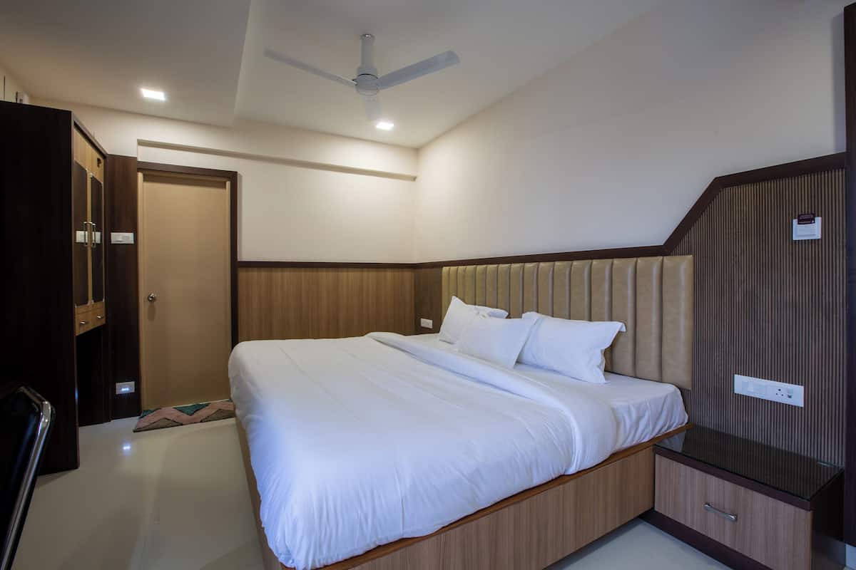 Un dormitorio con cama, armario, ventilador de techo y mesita de noche.