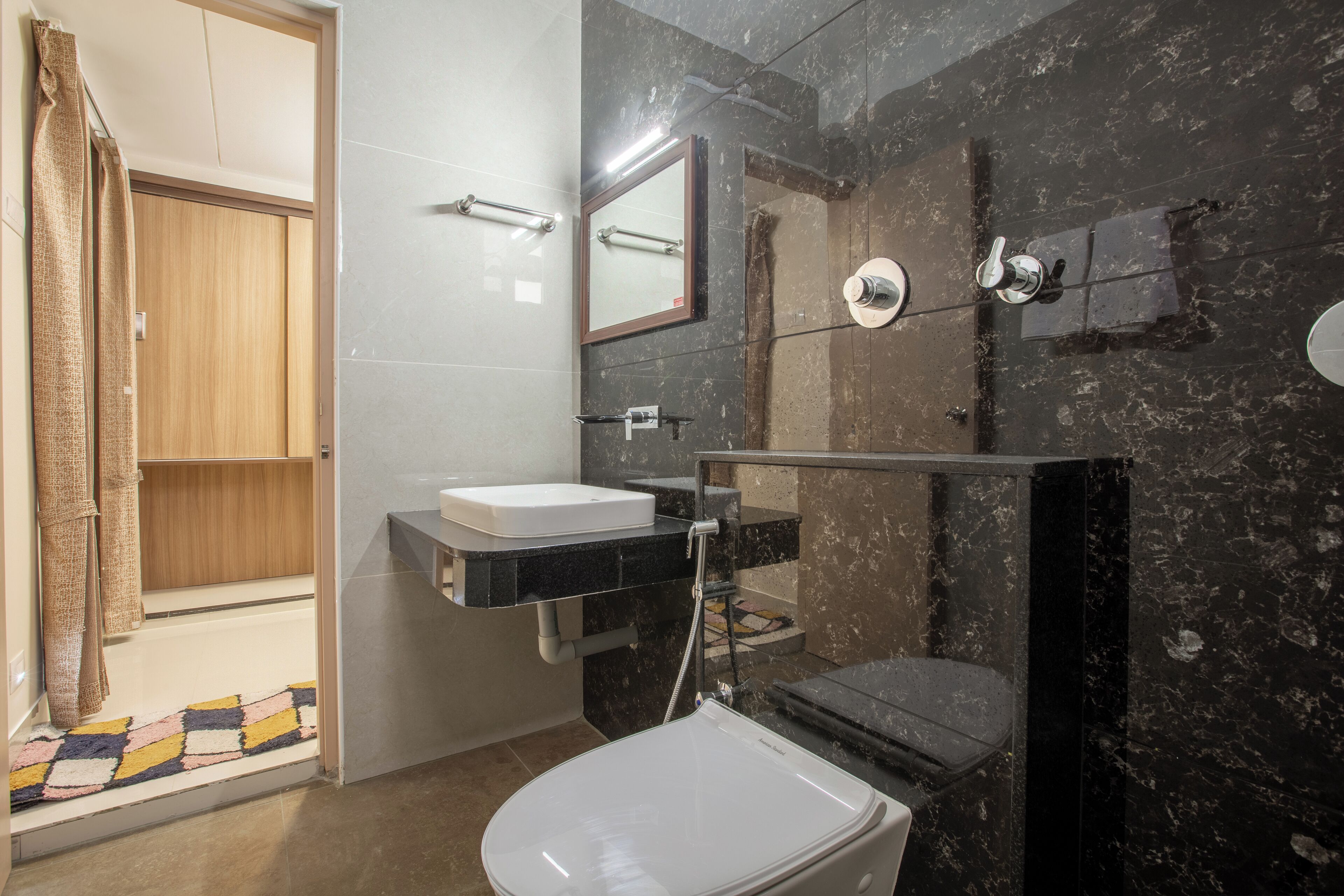 A modern bathroom with a white toilet, a sink, and a shower area.
