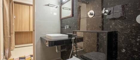 A modern bathroom with a white toilet, a sink, and a shower area.