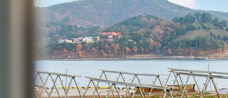 A view of a lake with a mountain in the background and a row of empty chairs in the foreground.