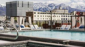 A pool area with lounge chairs and a view of mountains in the background.
