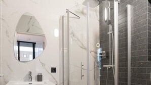 A modern bathroom with a glass-enclosed shower, a marble-tiled floor, and a wooden vanity. - LevelUp Sunrise (Amsterdam)