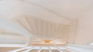 Un intérieur moderne avec un escalier central menant à un espace lumineux et ouvert.