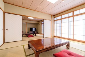 A traditional Japanese room with tatami flooring, a wooden table, and sliding doors. - PiDDs Family Kinomiya (Atami)