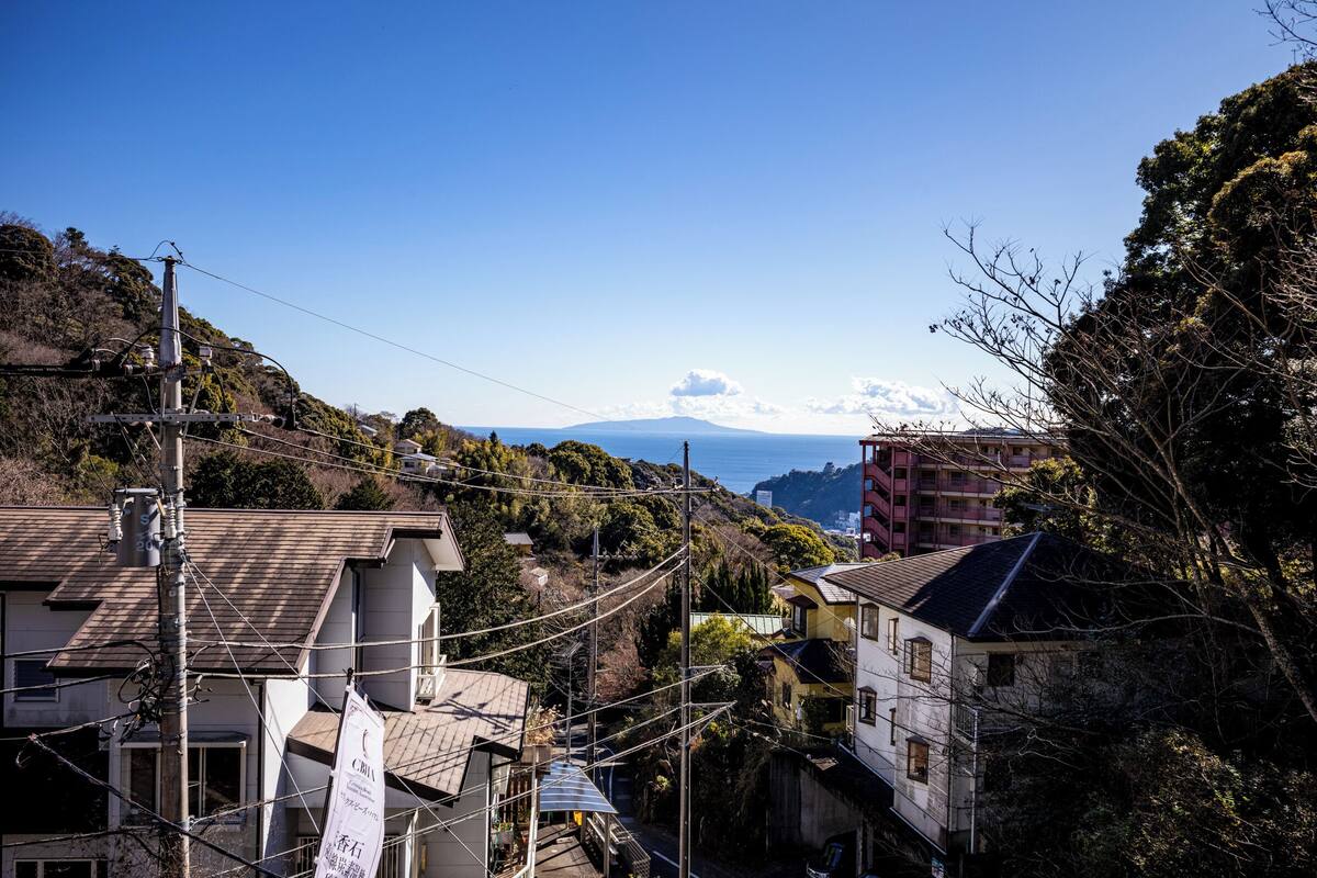 A residential area with houses, power lines, and a distant mountain view.
