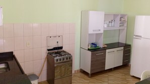 Une cuisine équipée d’une cuisinière, de placards et d’un réfrigérateur.