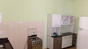 Frigorífico, placa de cocina, utensilios de cocina y mesa de comedor