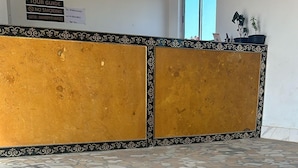 A reception area with a check-in counter, a tiled floor, and framed certificates on the wall. - Raghav Resort Jaisalmer (Jaisalmer)