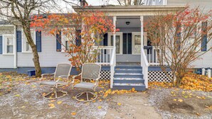 A porch with two rocking chairs, a white fence, and a staircase leading to a house with blue shutters. - 1 Block to Downtown Adrian: Spacious Home! (Adrian)