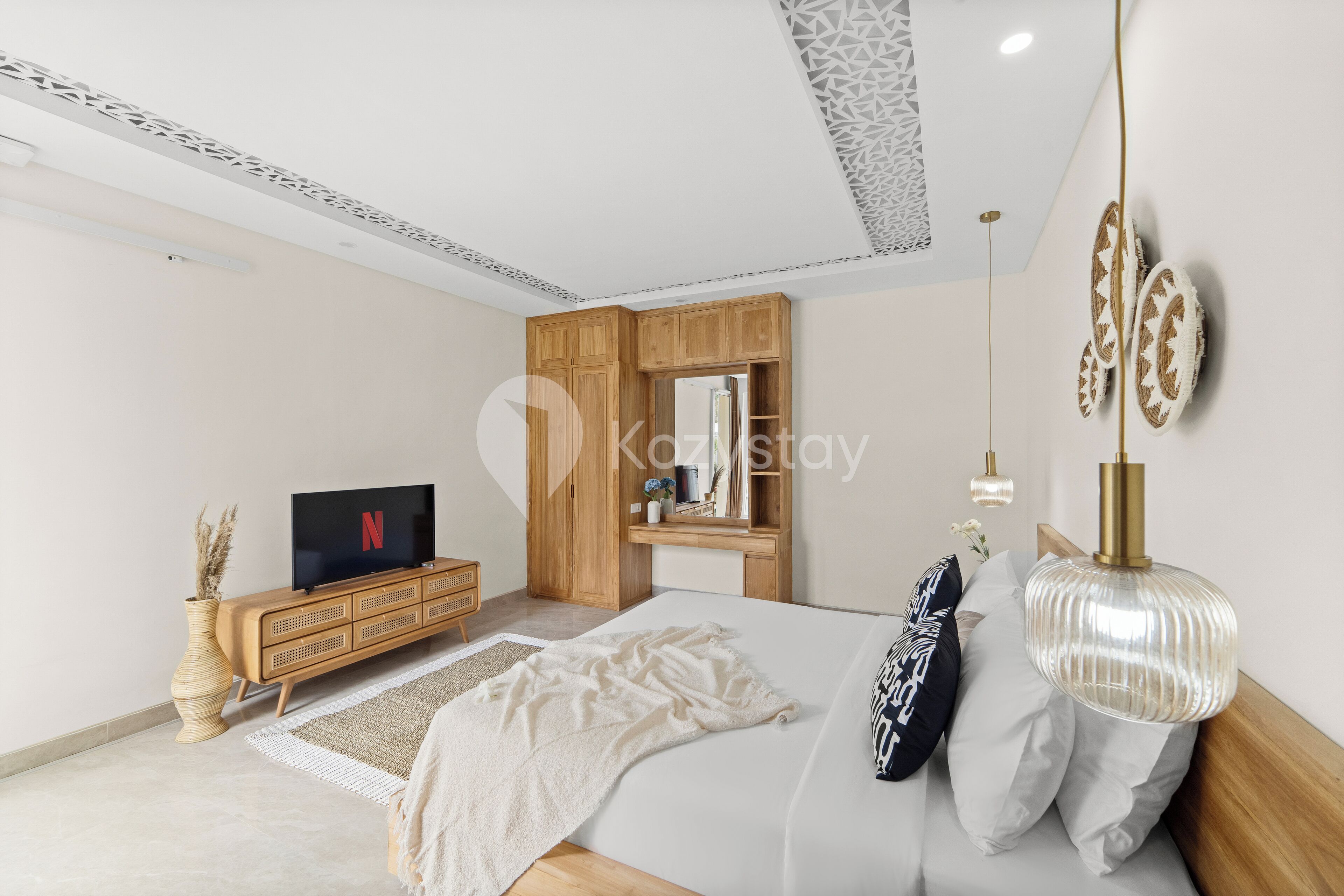 Una camera da letto moderna con un letto, un armadio in legno, una TV e elementi decorativi a parete.