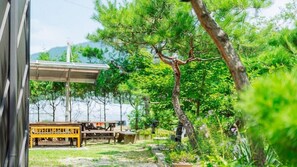 A garden with a wooden bench, a table, and a pergola. - Chuncheon Stay 266 (Chuncheon)