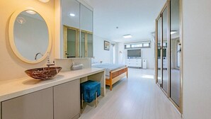 A modern bedroom with a large mirror, a wooden bed, a bedside table, and a TV. - Chuncheon Stay 266 (Chuncheon)