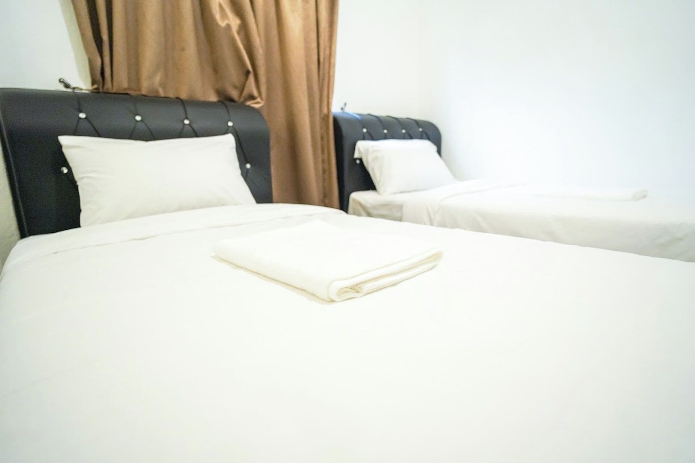 Une chambre d’hôtel avec deux lits, chacun doté d’une tête de lit et d’oreillers.