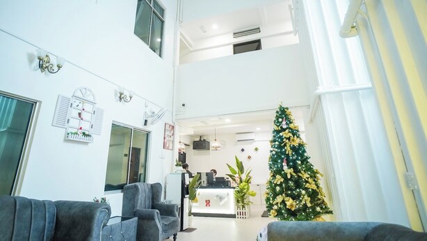 A spacious lobby with a reception desk, a Christmas tree, and seating areas. - B Link Hotel (Kulai)