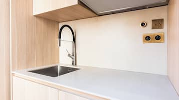 A modern kitchen with a stainless steel sink, a sleek faucet, and a range hood above the stove.