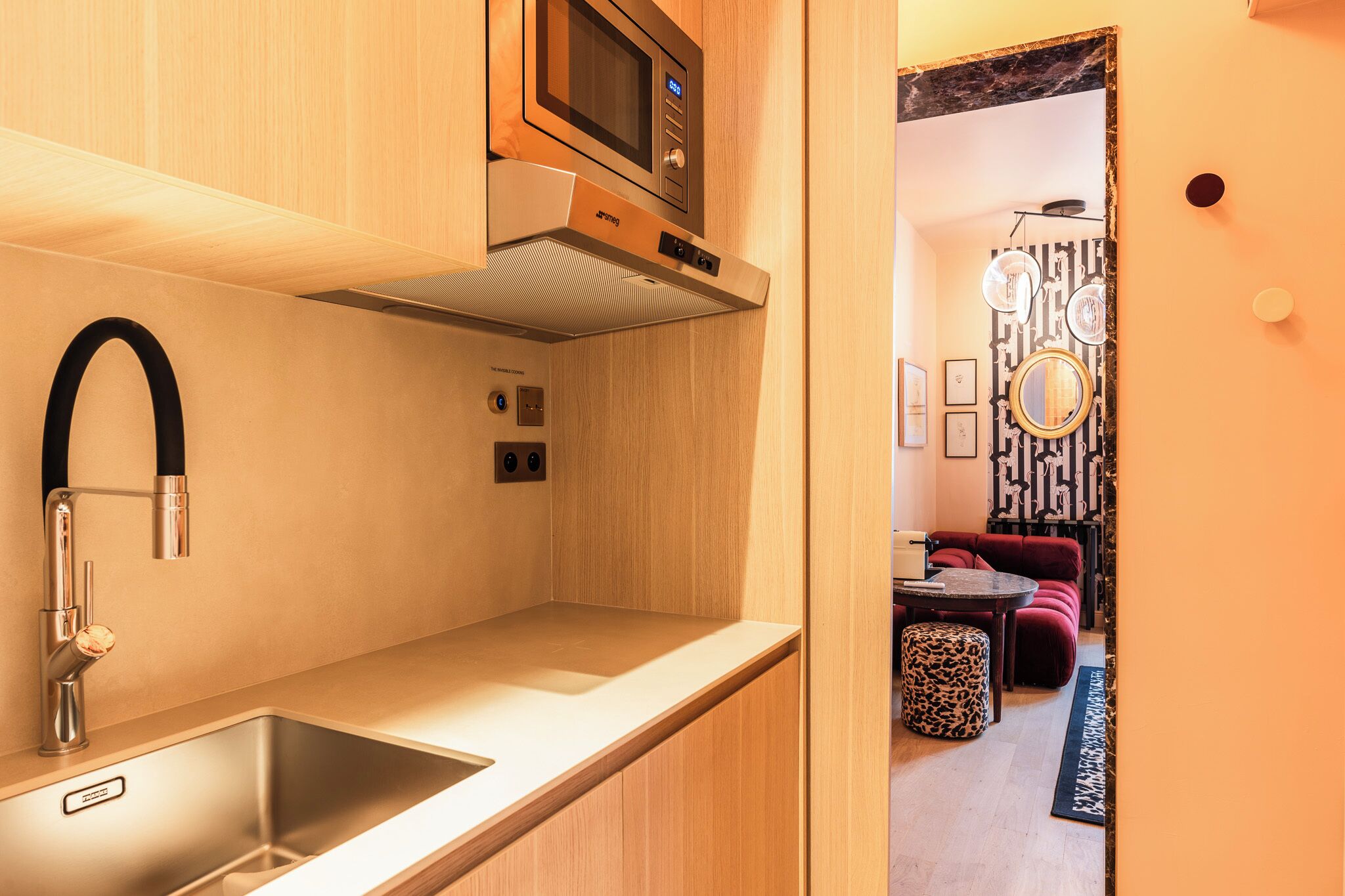 Een moderne keuken met een roestvrijstalen spoelbak, een magnetron en een ingebouwde oven.