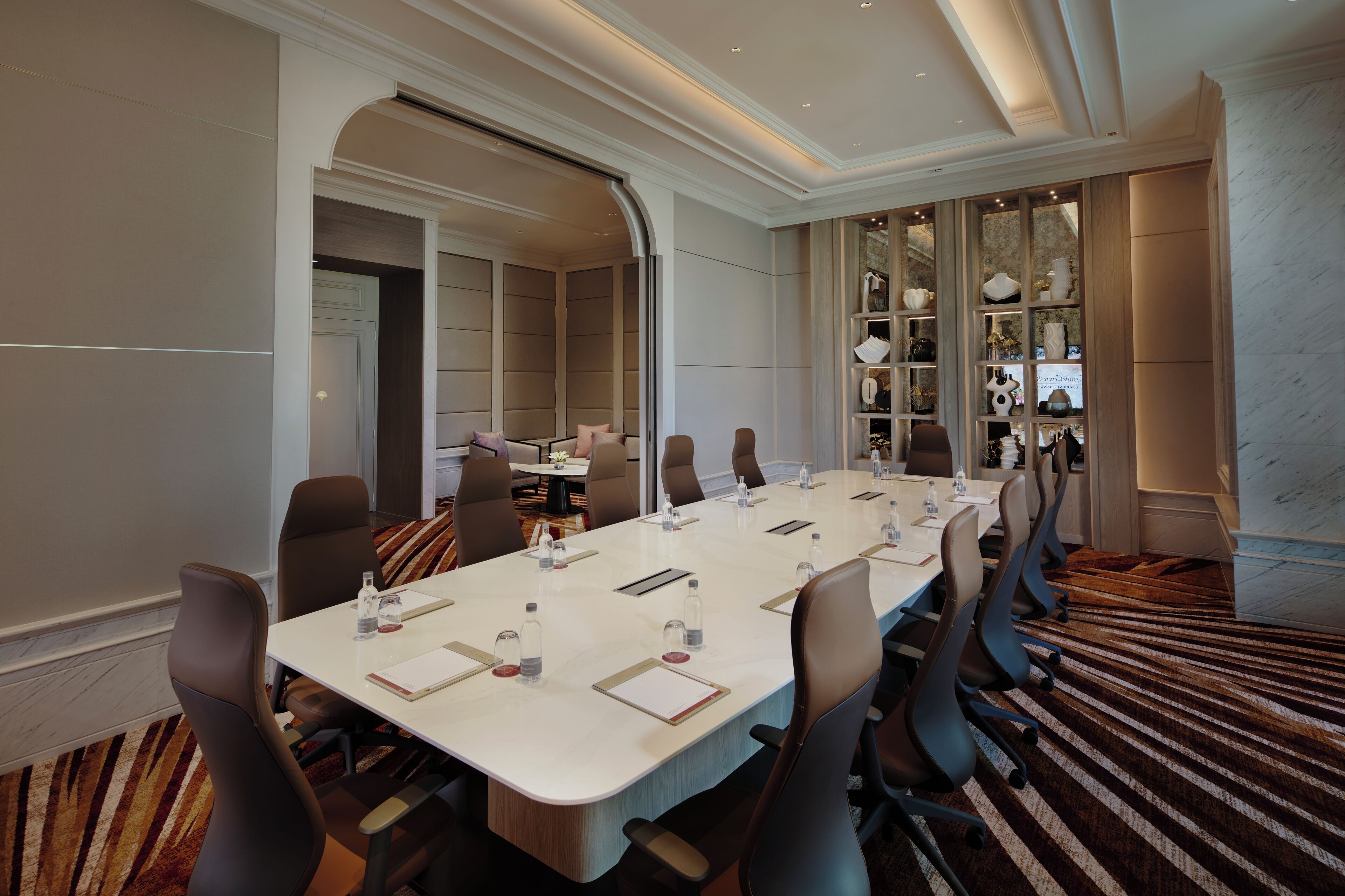 A conference room with a long table, chairs, and a decorative wall display.