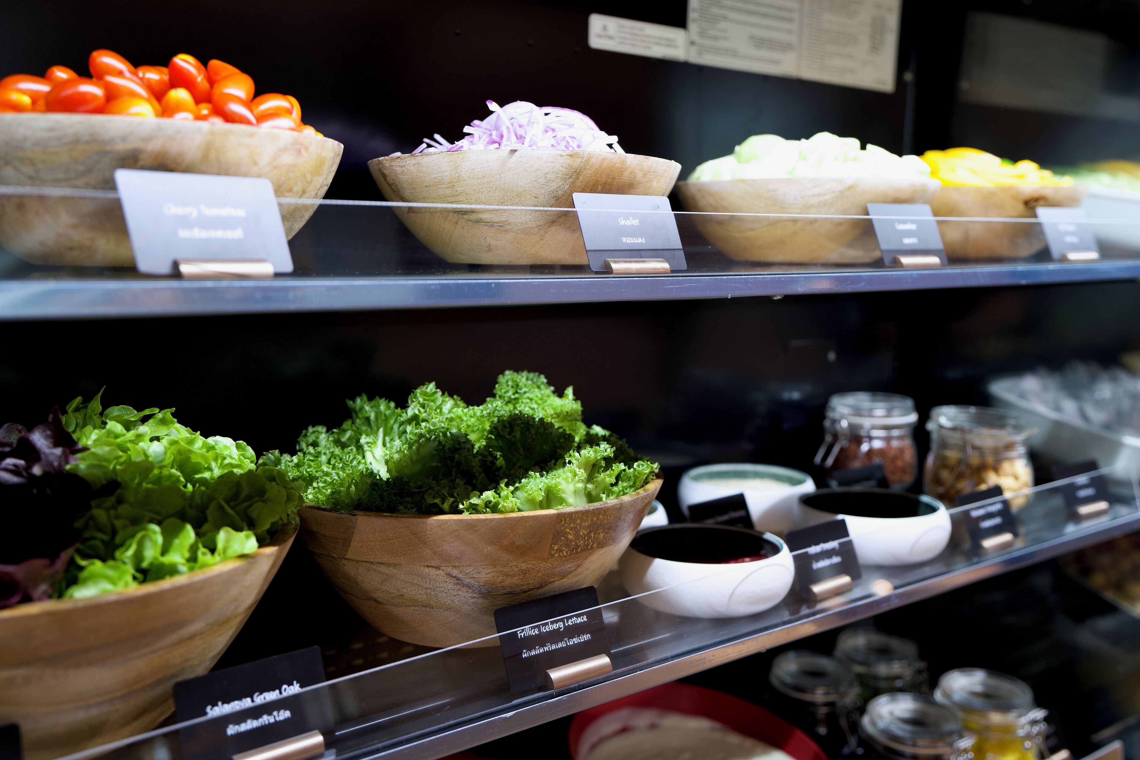 A salad bar with various fresh vegetables and dressings.