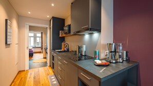 Una cocina moderna con microondas, estufa y cafetera integrados.