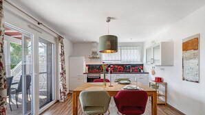 Una cucina moderna con zona pranzo, ampie finestre e vista sull'esterno.