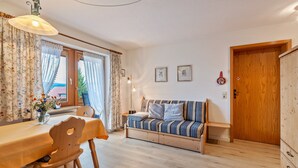 A cozy room with a wooden dining table, a sofa, and a wooden cabinet.