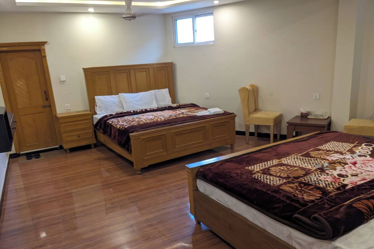 Ein Schlafzimmer mit einem hölzernen Bett, einem Nachttisch, einem Stuhl und einem Kleiderschrank.