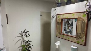 Ein Badezimmer mit Waschbecken, Spiegel und einem Blumentopf.