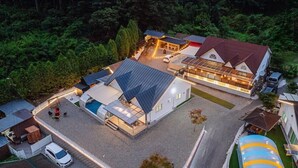Un edificio moderno con piscina, area relax all'aperto coperta e un carport.