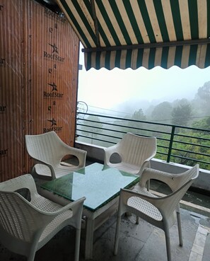 Enjoy a serene forest view from this sheltered outdoor space, complete with a table and comfortable seating for four.