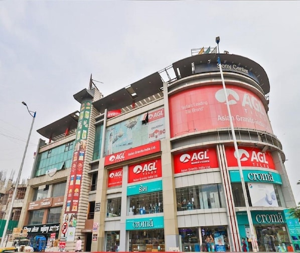 A multi-story commercial building with prominent AGL Tiles and Croma signage.