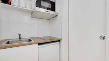 Una cocina moderna con un lavamanos de acero inoxidable, un microondas integrado y un lavavajillas.