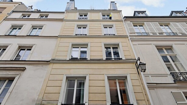 Un edificio a più piani con uno stile architettonico classico, caratterizzato da finestre e balconi simmetrici.