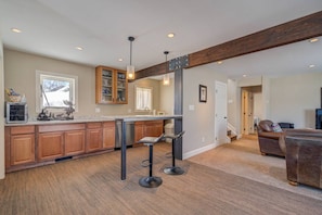 A spacious kitchen with wooden cabinets, a central island, and pendant lighting. - Downtown Dog Friendly Home w/Views-Walk to Ski Bus (Steamboat Springs)