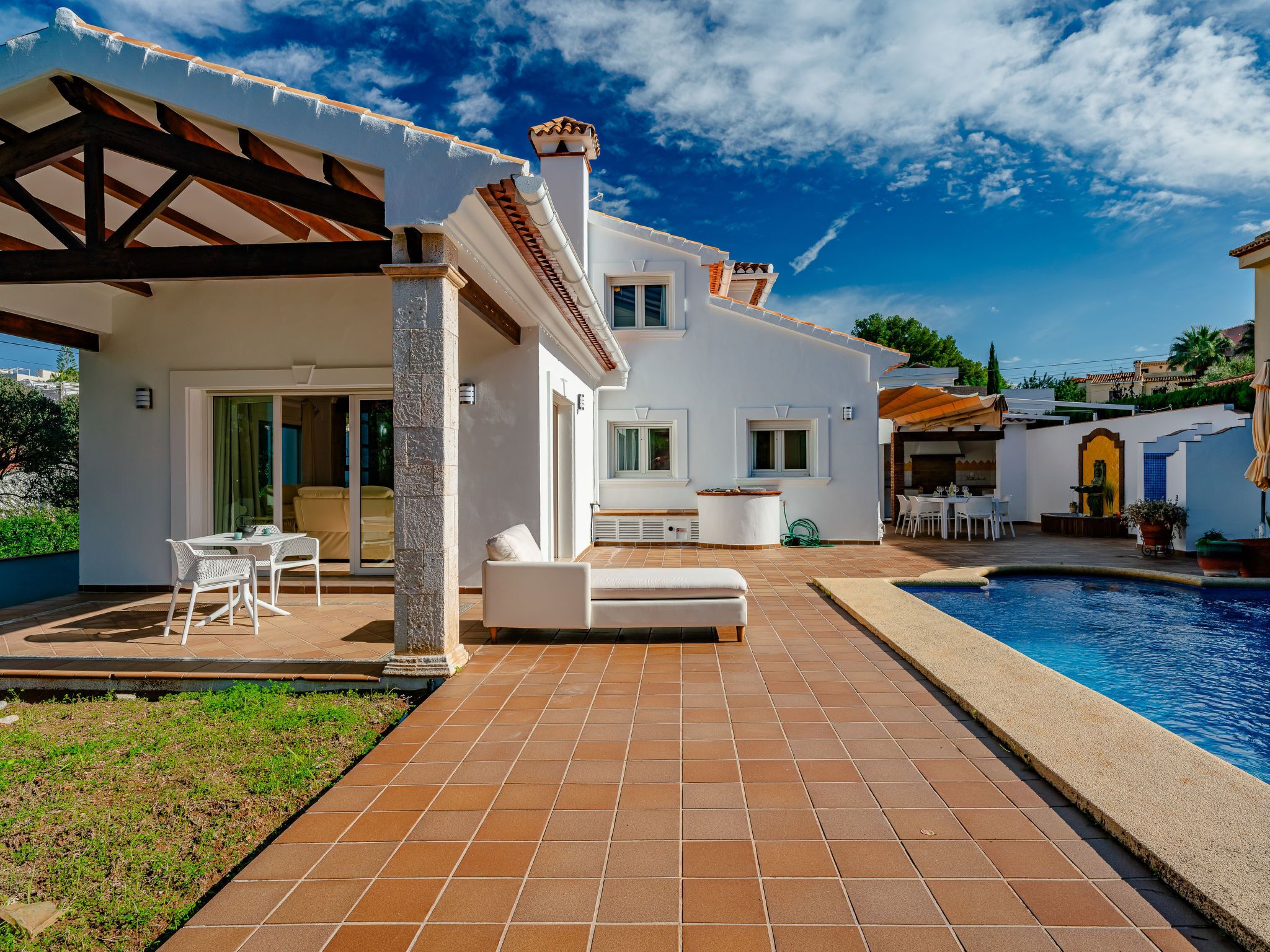Une villa moderne dotée d’une piscine, d’un espace salon extérieur et d’un patio couvert.