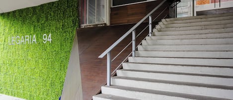 A staircase with a green wall and a wooden handrail.