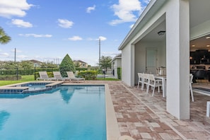 Step outside to your private oasis with a sleek pool and stylish lounge chairs. The spacious patio, complete with modern outdoor dining, invites you to enjoy meals alfresco while basking in the sunshine. - 5BR house sleeps 10 with pool table and spa (Kissimmee)