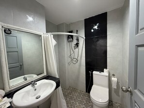 Signature tweepersoonskamer | Badkamer | Een douche, een haardroger, handdoeken, zeep