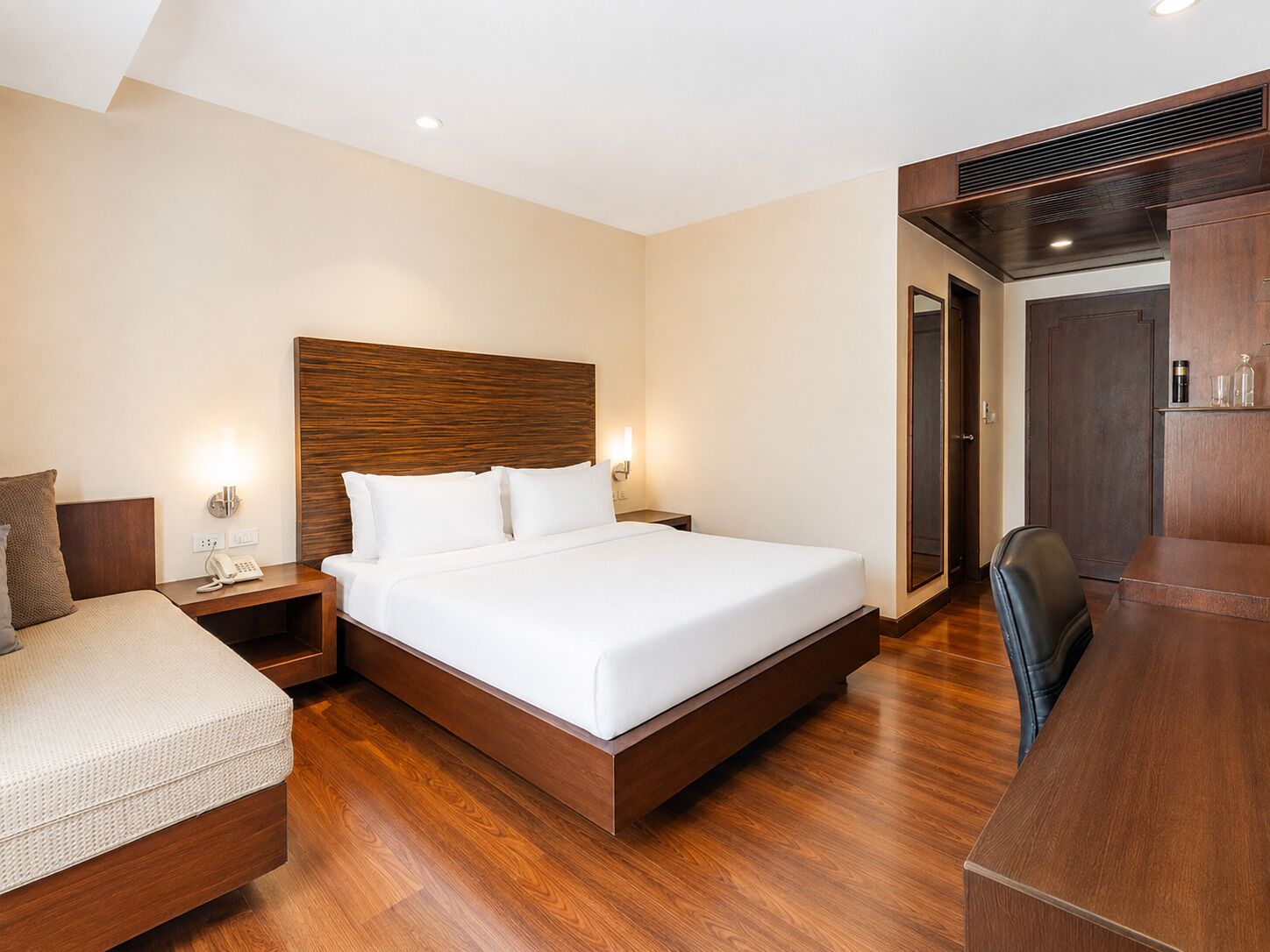 Una habitación de hotel con una cama grande, un escritorio y una silla.
